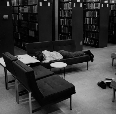 A student sleeping on one of the sofas in Burling Library.