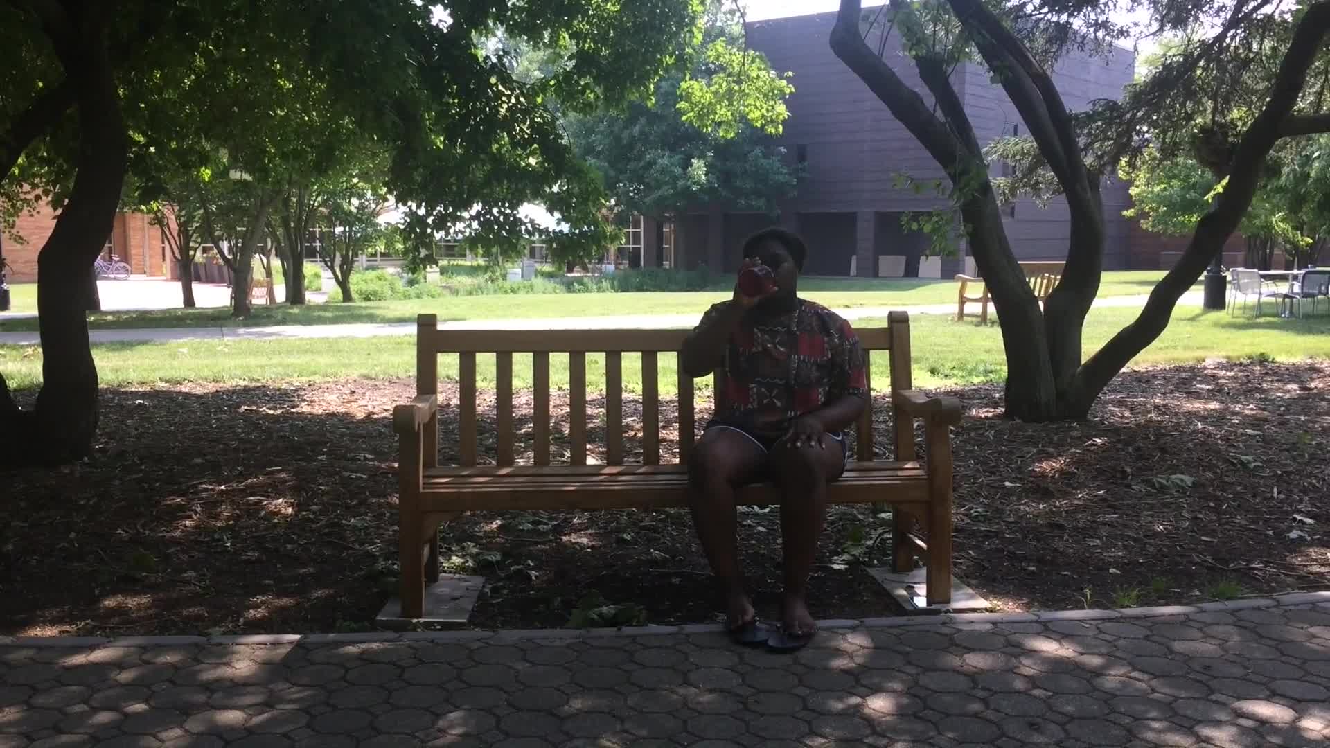  Dances from prompts inspired by Yoko Ono's Grapefruit. Naomi Worob in skirt with striped shirt dancing outside with arms above her head next to exposed pipes. Obuchi Adikema dancing while sitting on a bench.